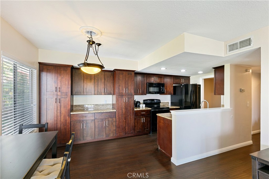 1517 East Garfield Avenue, Unit 53 Glendale, CA 91205 - Photo 7 of 53 a kitchen with granite countertop stainless steel appliances and wooden cabinets