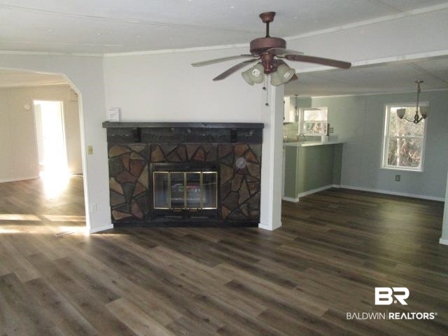 14791 Raber Road Summerdale, AL 36580 - Photo 11 of 21 Unfurnished living room with a stone fireplace, ceiling fan, dark wood-type flooring, and crown molding