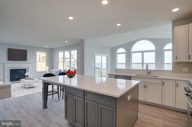 a kitchen with a stove a refrigerator and a dining table with wooden floor
