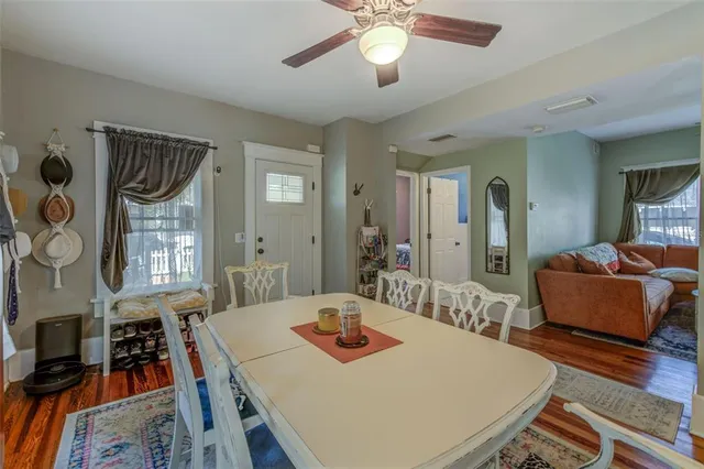 a kitchen with stainless steel appliances granite countertop a refrigerator a sink dishwasher a stove and a dining table with wooden floor