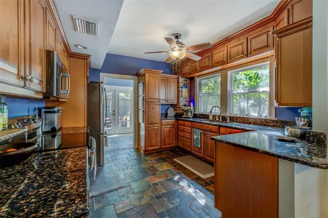 a large kitchen with stainless steel appliances granite countertop a stove and a sink