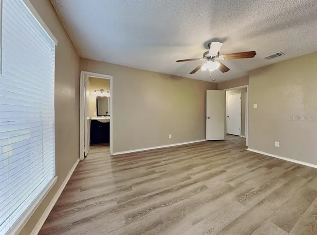 wooden floor in an empty room with a chandelier