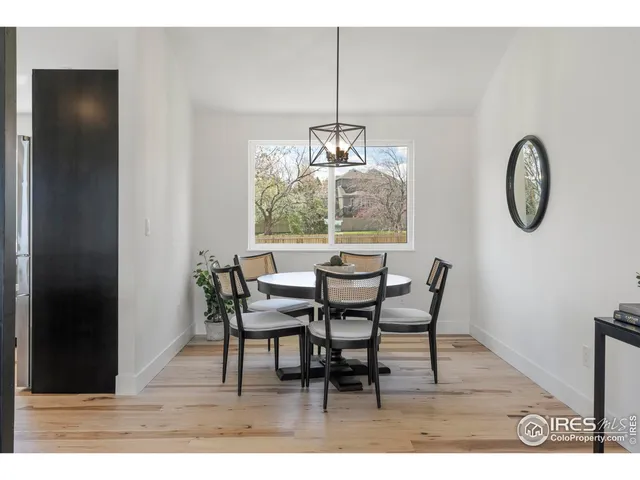 a dining room with furniture a potted plant and wooden floor