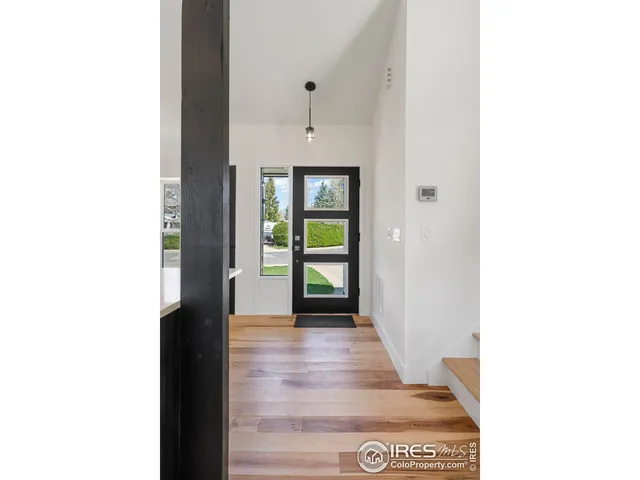 a view of a hallway with wooden floor and a large window