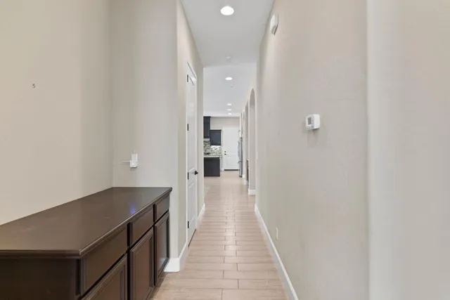 a view of a hallway with wooden floor and staircase