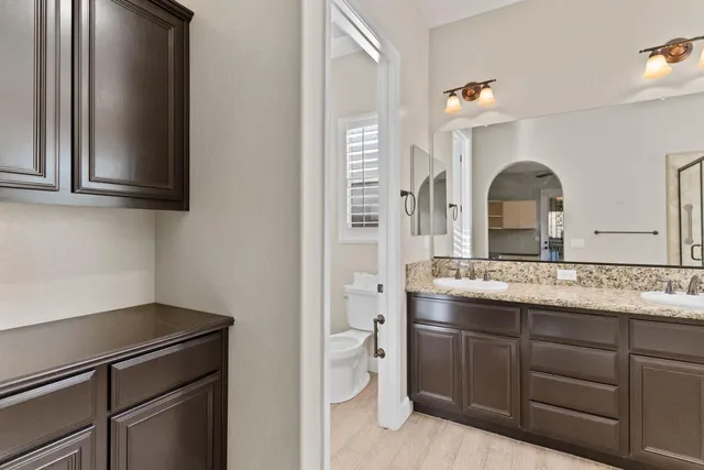 a kitchen with a sink and a stove with wooden floor