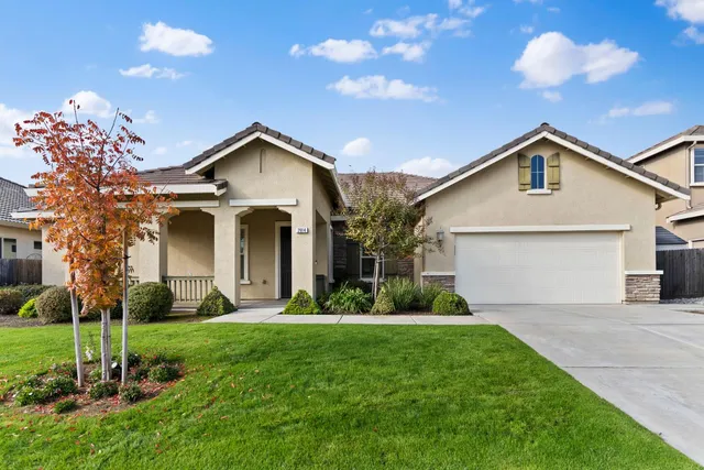 a front view of a house with a yard and garage