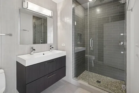 a bathroom with a shower sink and mirror
