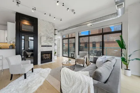 a living room with furniture large window and a fireplace