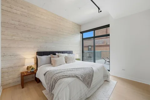 a large bed sitting in a bedroom next to a window