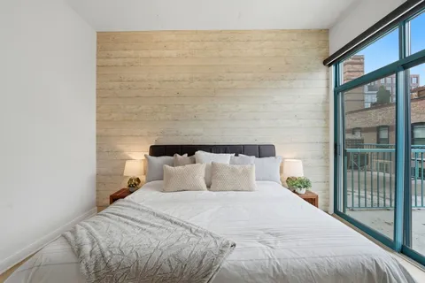 a bedroom with a bed and a large window