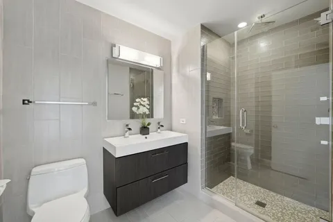 a bathroom with a sink a toilet and shower