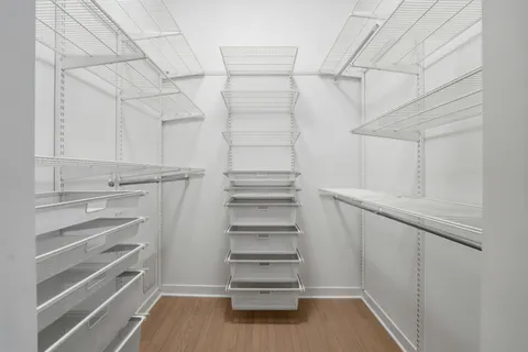 a view of walk in closet with empty racks