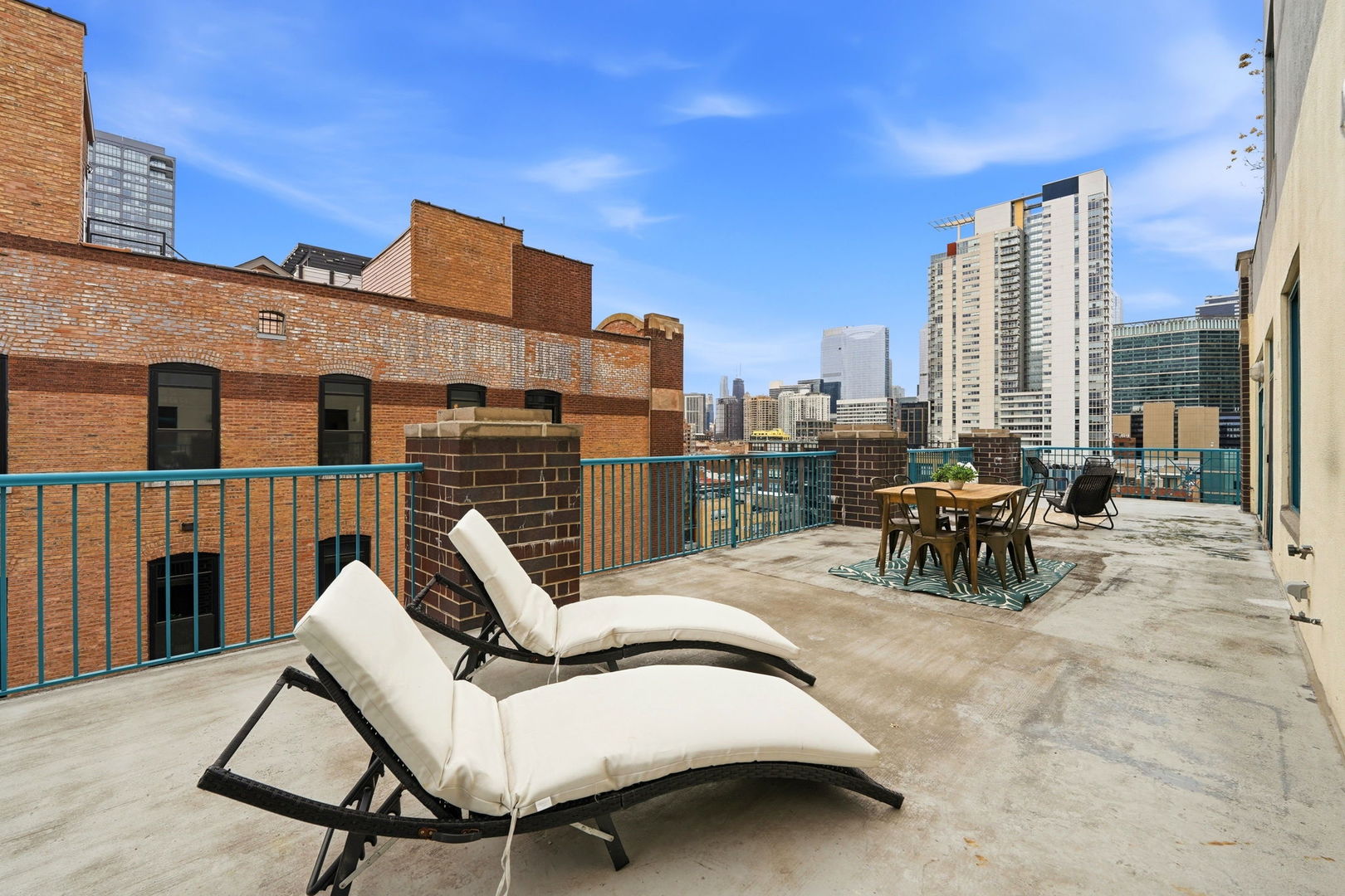 910 West Madison Street, Unit 808 Chicago, IL 60607 - Photo 26 of 37 a view of roof deck with table and chairs couches under an umbrella with wooden floor