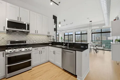 a kitchen with stainless steel appliances a stove a sink and a microwave