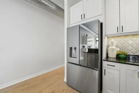 a view of a refrigerator in kitchen and wooden floor