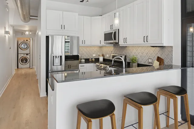 a kitchen with stainless steel appliances granite countertop a stove a sink and a refrigerator