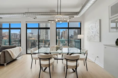 a view of a dining room with furniture large windows and wooden floor