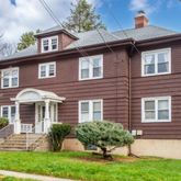 a front view of a house with yard and green space