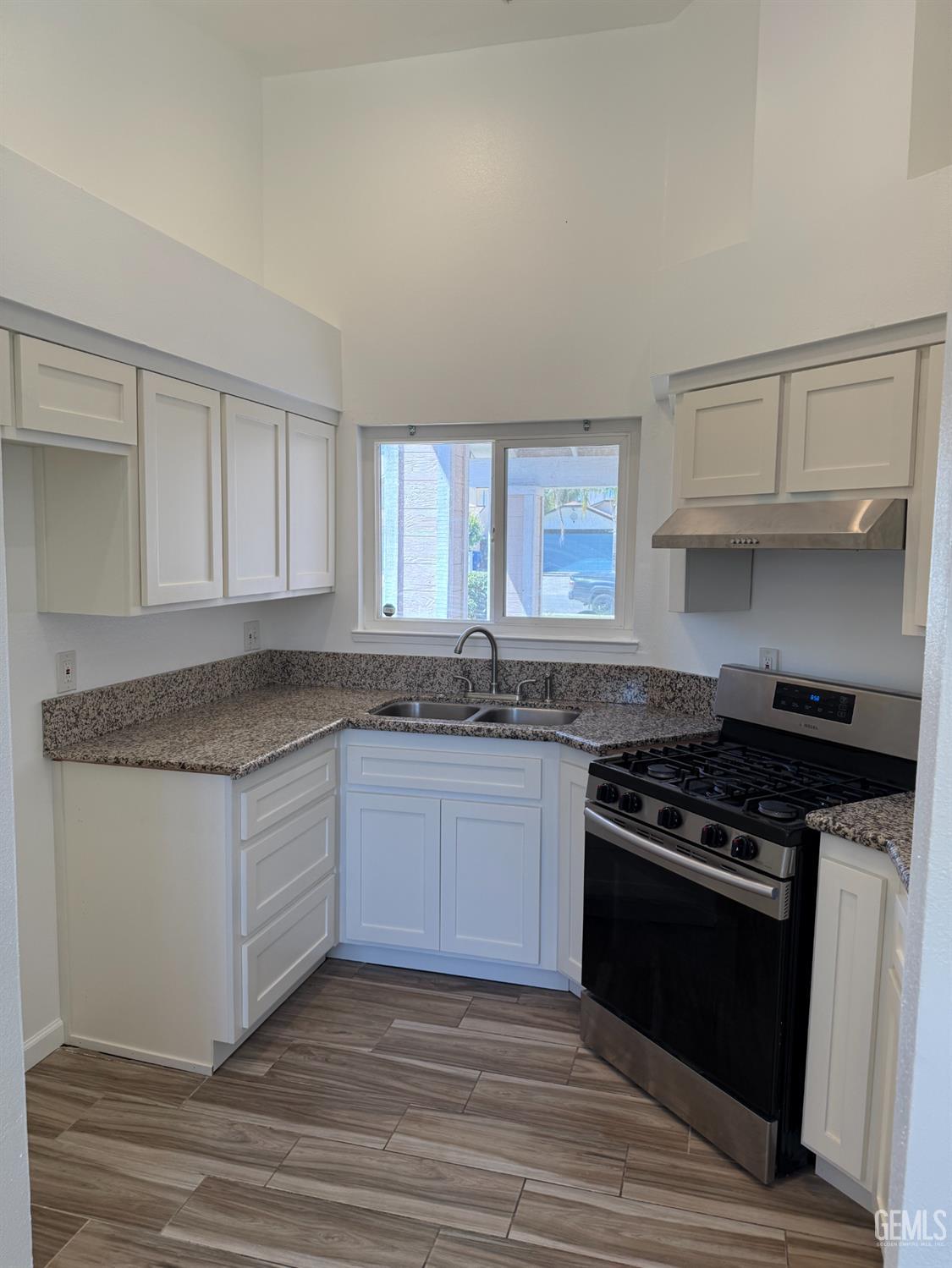 Undisclosed Address Bakersfield, CA 93307 - Photo 2 of 11 a kitchen with granite countertop a stove and a sink