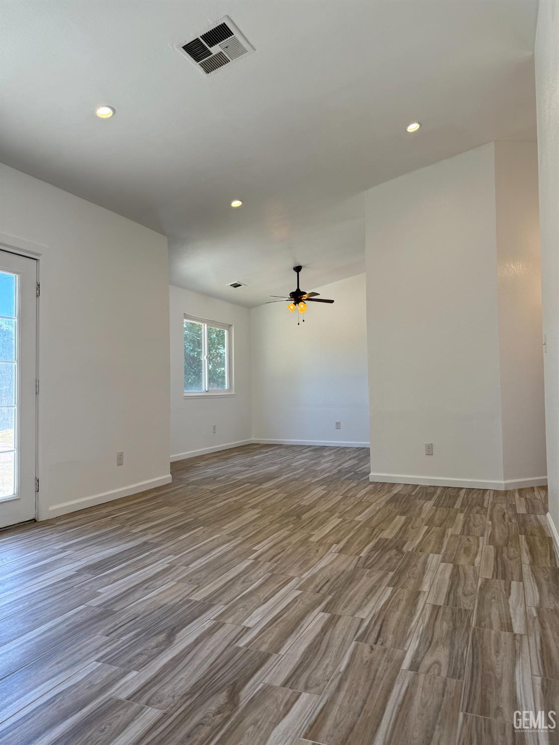 Undisclosed Address Bakersfield, CA 93307 - Photo 4 of 11 an empty room with wooden floor and windows