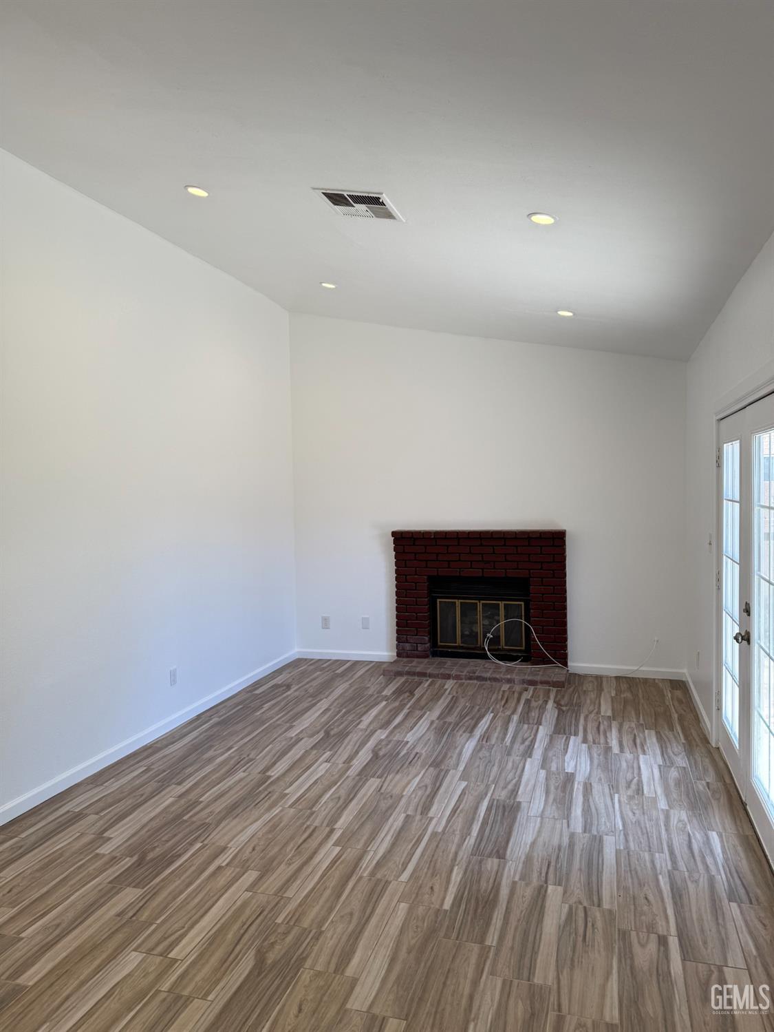 Undisclosed Address Bakersfield, CA 93307 - Photo 5 of 11 wooden floor in an empty room with a window
