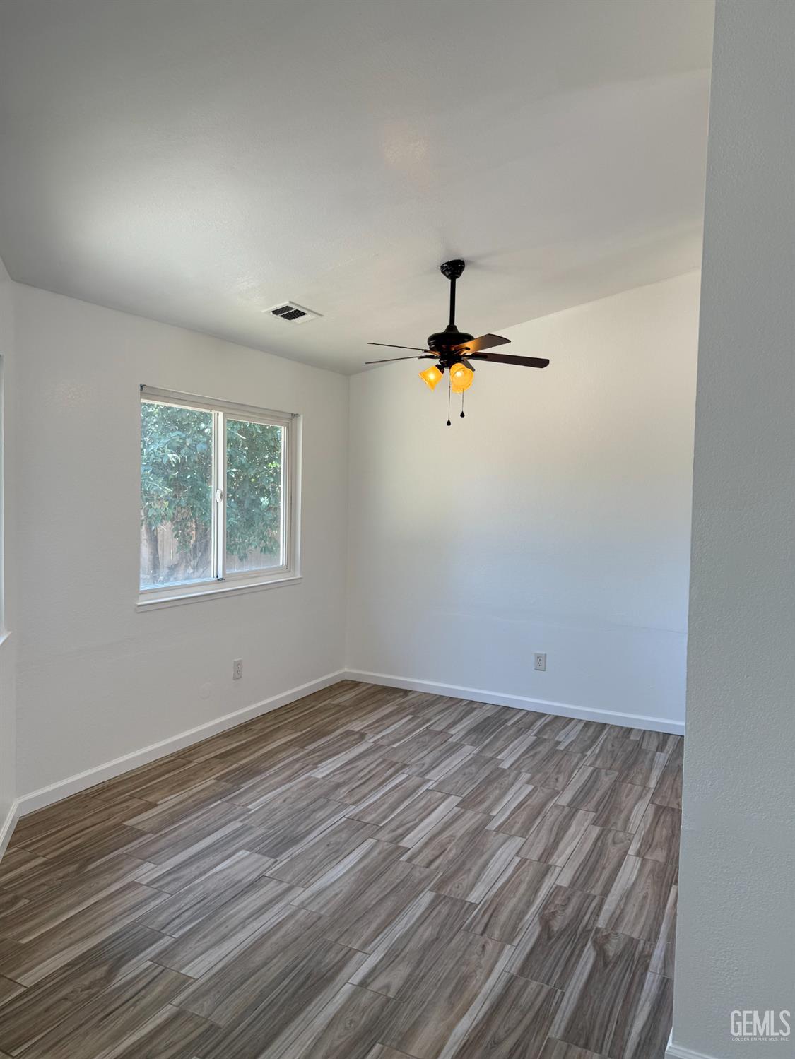 Undisclosed Address Bakersfield, CA 93307 - Photo 9 of 11 a view of a room with a wooden floor and white walls