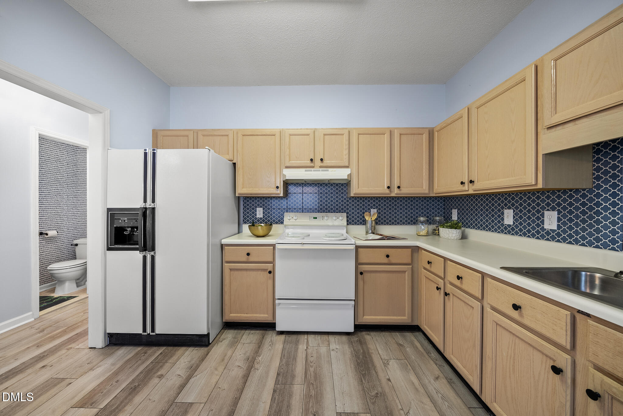 4126 Beaufain Street Raleigh, NC 27604 - Photo 5 of 36 a kitchen with a refrigerator sink and cabinets