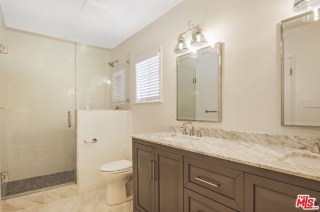 a bathroom with a granite countertop sink a toilet and a mirror