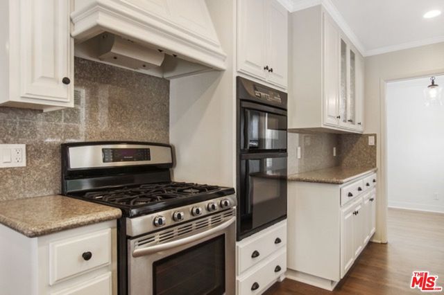a kitchen with granite countertop a stove and a refrigerator