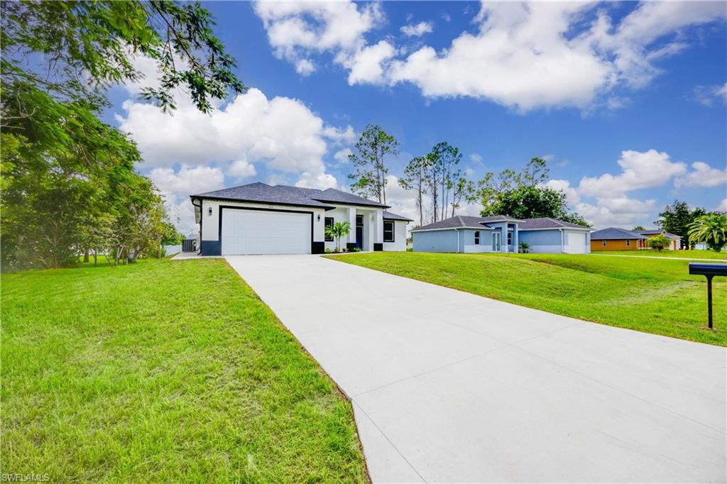 228 Connecticut Road Lehigh Acres, FL 33936 - Photo 2 of 21 a view of house with garden and trees