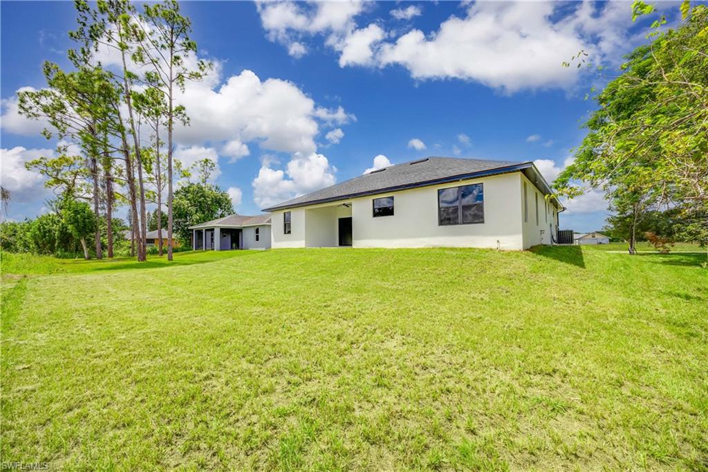 228 Connecticut Road Lehigh Acres, FL 33936 - Photo 21 of 21 a front view of house with yard and trees