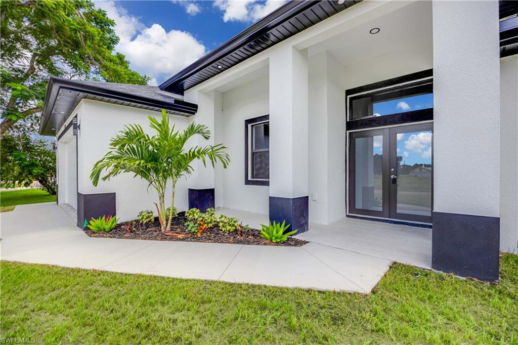 228 Connecticut Road Lehigh Acres, FL 33936 - Photo 3 of 21 a front view of a house with a yard and outdoor seating