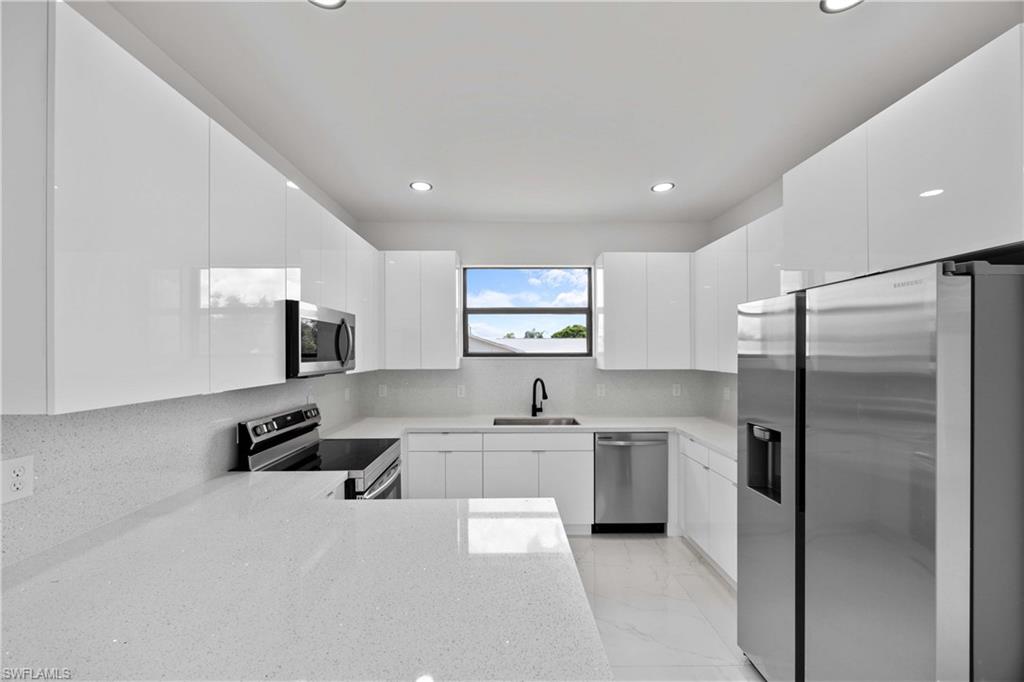 228 Connecticut Road Lehigh Acres, FL 33936 - Photo 8 of 21 a kitchen with a sink stainless steel appliances and cabinets