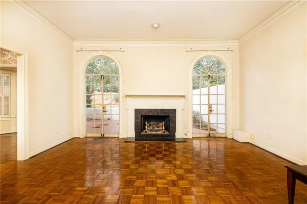 an empty room with windows and fireplace