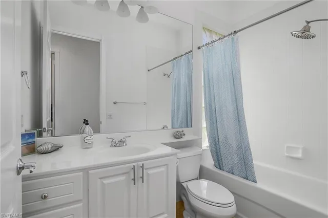 a bathroom with a sink a toilet a mirror and shower