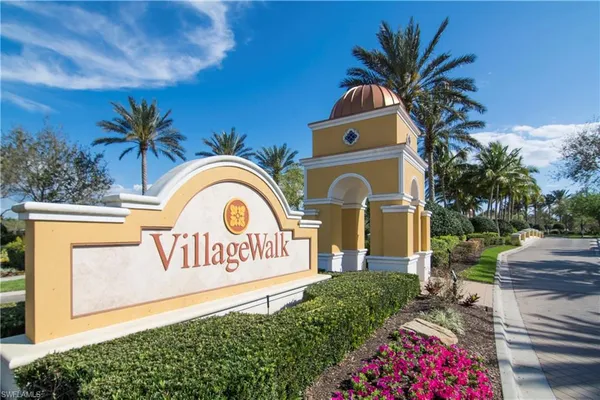 a view of sign board with flower plants and wooden fence