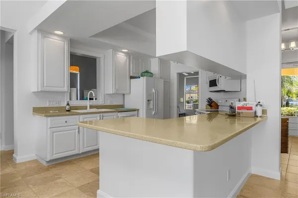 a kitchen with stainless steel appliances granite countertop a sink and a refrigerator