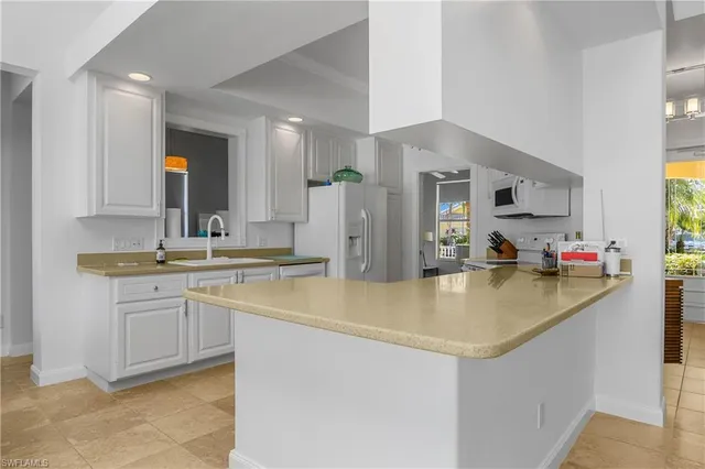 a kitchen with stainless steel appliances granite countertop a sink and a refrigerator