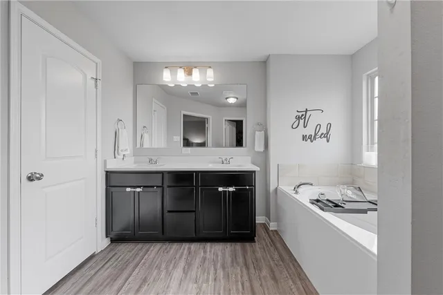 a bathroom with a sink a large mirror and a bathtub