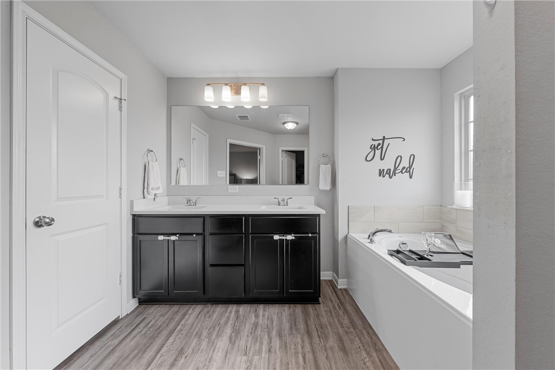 4016 Bravo Ranch Road Waco, TX 76705 - Photo 21 of 38 a bathroom with a sink a large mirror and a bathtub