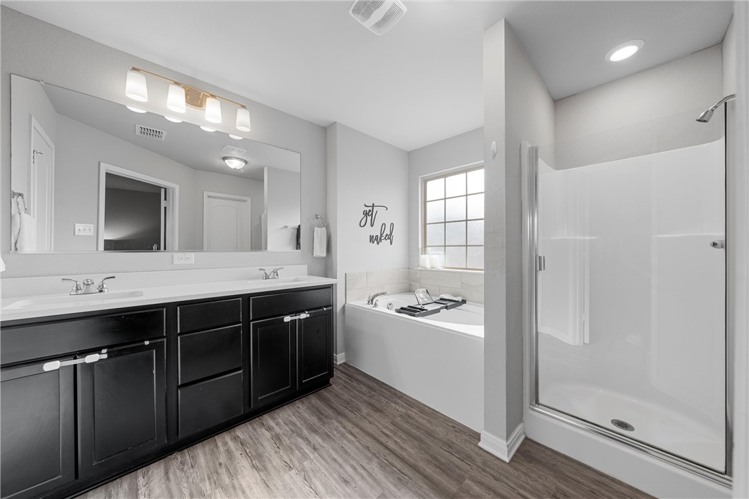 4016 Bravo Ranch Road Waco, TX 76705 - Photo 22 of 38 a spacious bathroom with a double vanity sink a mirror and shower