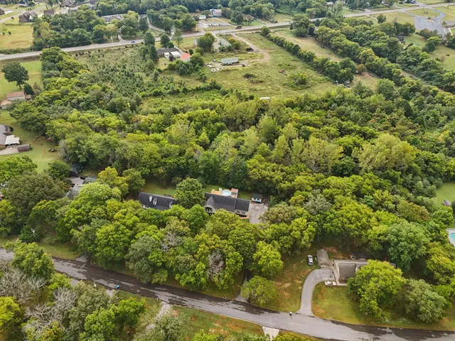 a kitchen with granite countertop a refrigerator a sink and white cabinets