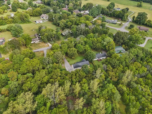 a kitchen with refrigerator and wooden floor