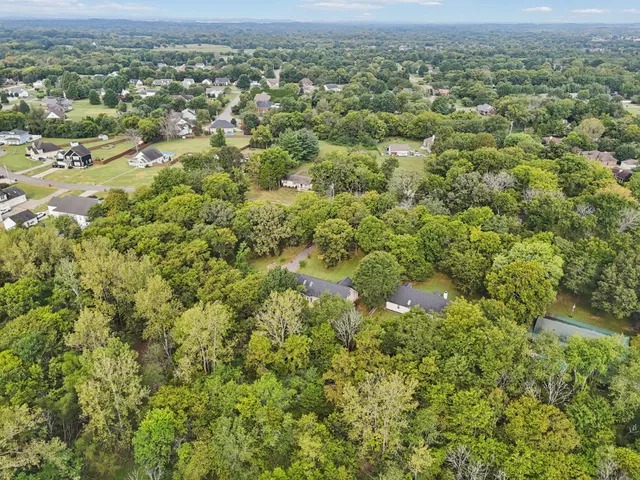 an empty room with wooden floor and ceiling fan