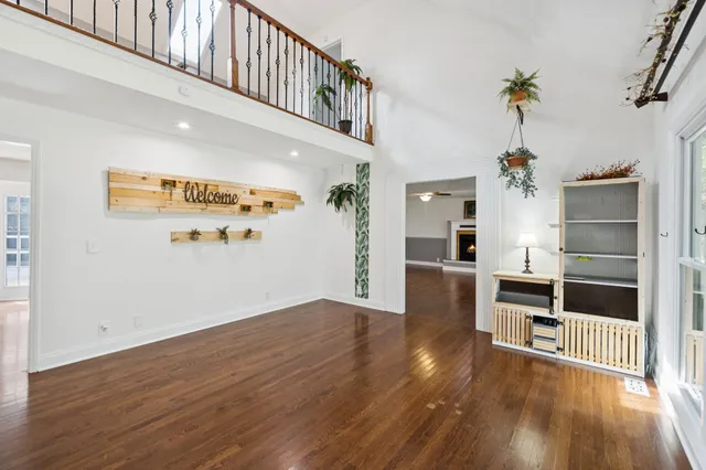 an empty room with windows and ceiling fan