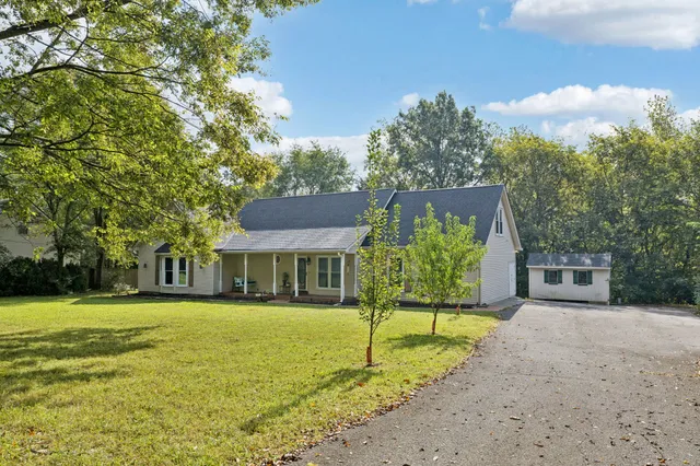 a view of an empty room with wooden floor fireplace and a window