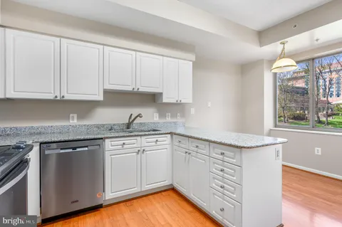 a kitchen with granite countertop white cabinets and white appliances