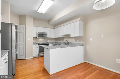a kitchen with stainless steel appliances granite countertop a refrigerator a stove a sink and a microwave