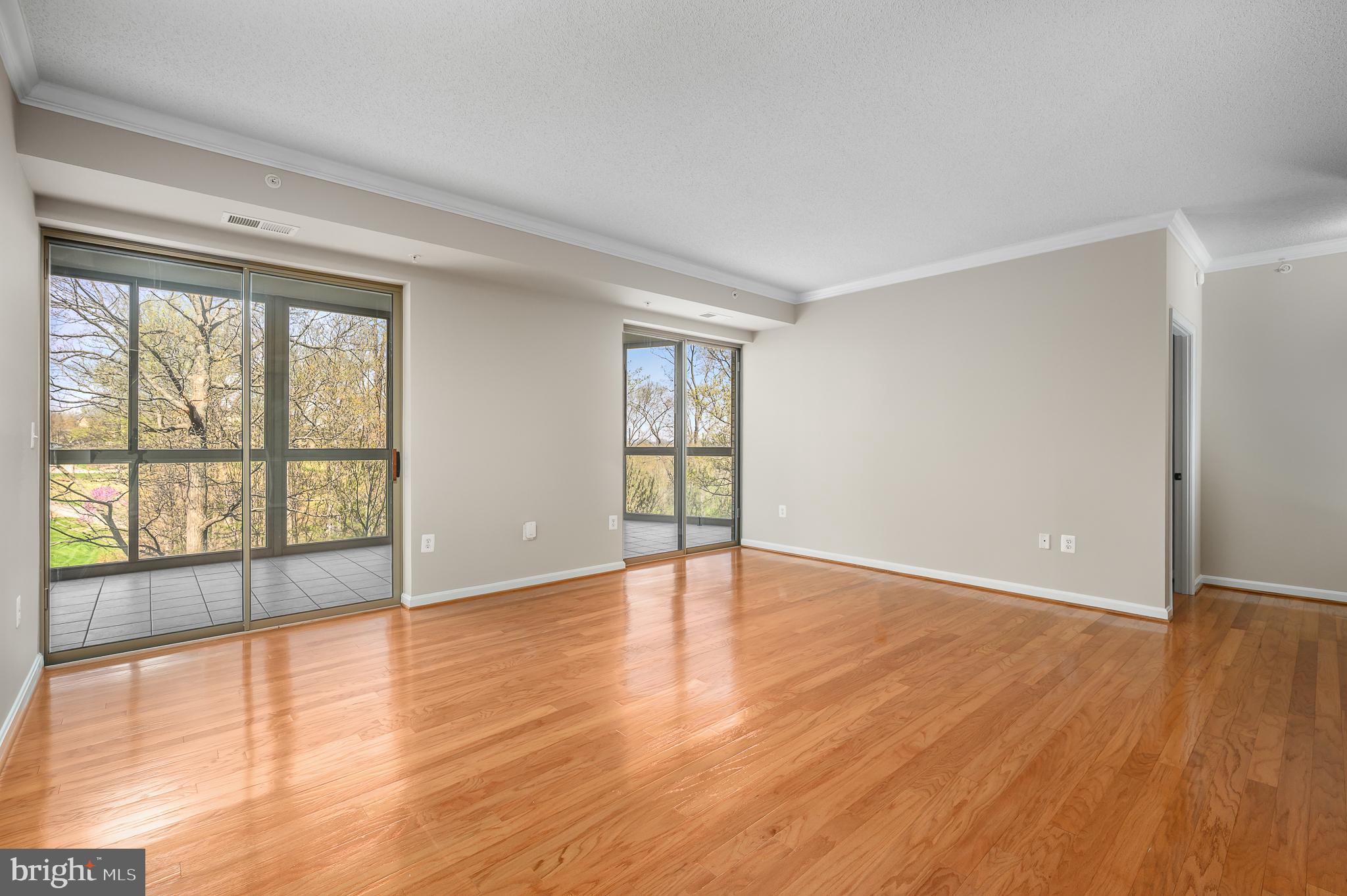 19355 Cypress Ridge Terrace, Unit 219 Leesburg, VA 20176 - Photo 3 of 42 a view of an empty room with wooden floor and a window